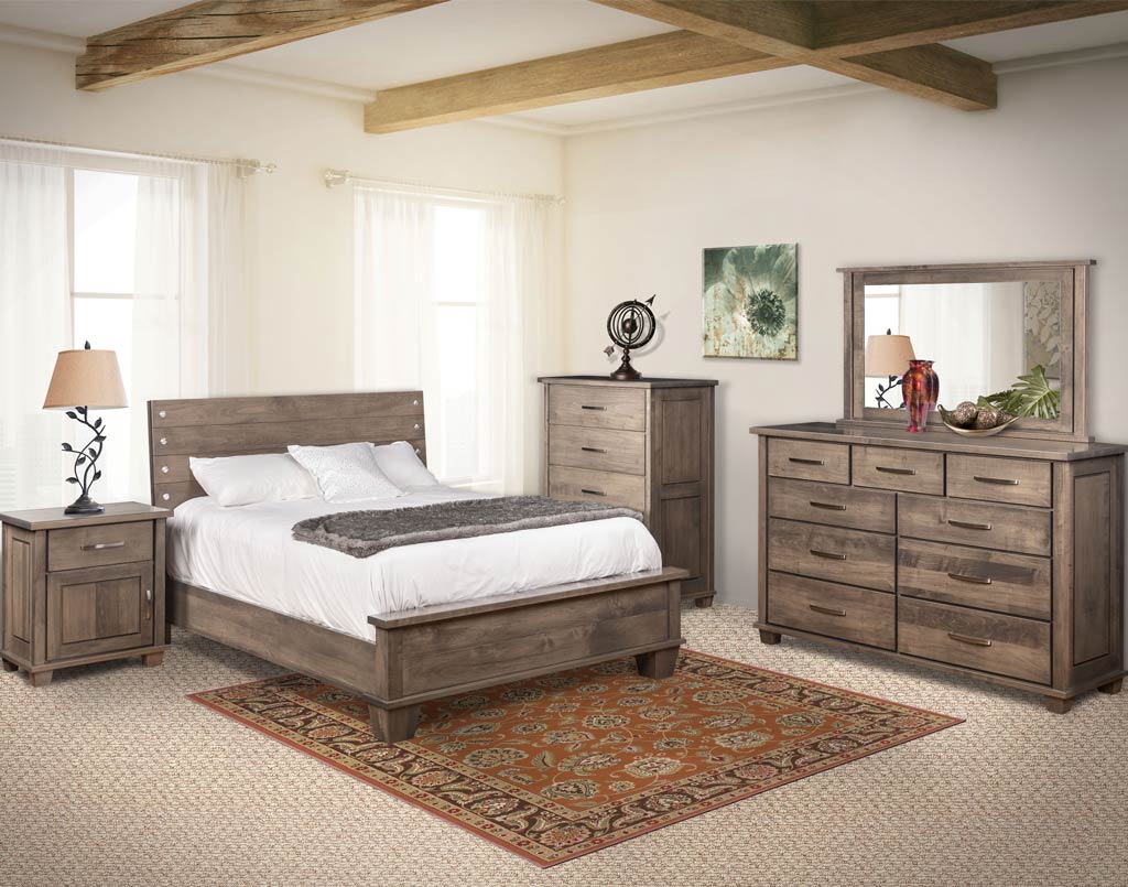 Wooden bedroom furniture set including bed, nightstands, and dresser in a room with white walls and wooden beams.