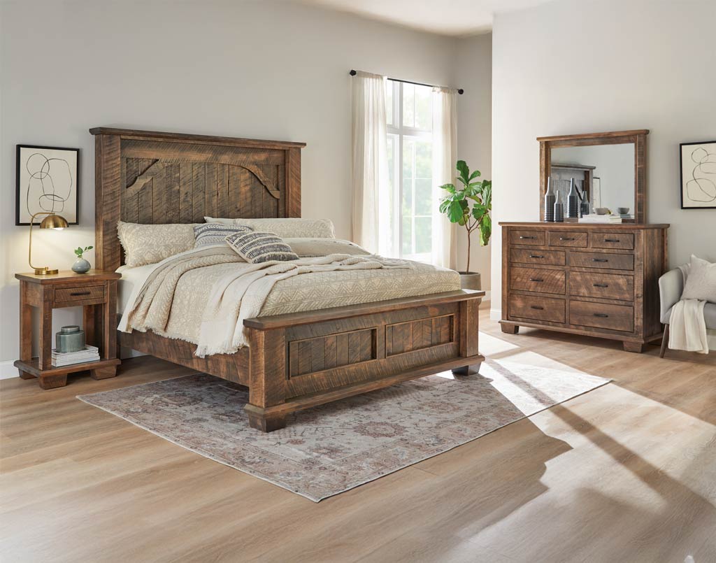 Wooden bedroom furniture set including bed, nightstand, dresser, and mirror in a room with light wood flooring and white walls. Full collection coming soon