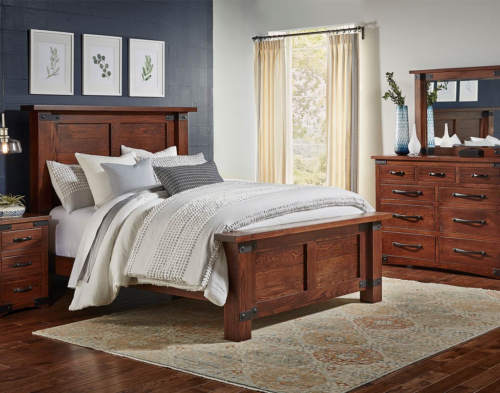 Wooden bedroom set with bed, nightstands, and dresser in a room with a window and decor.