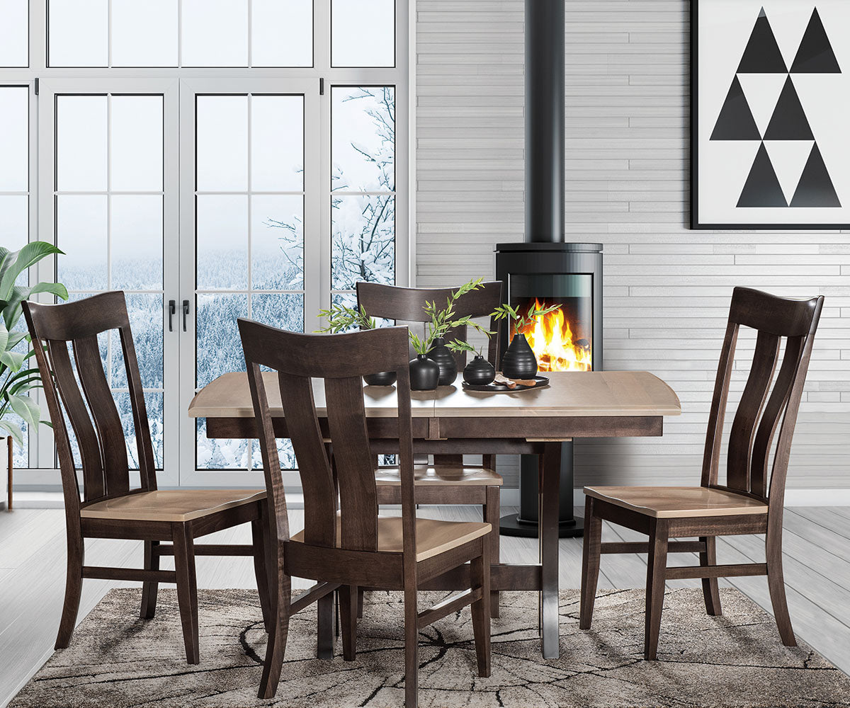 Dining room with wooden table and chairs in front of a fireplace.