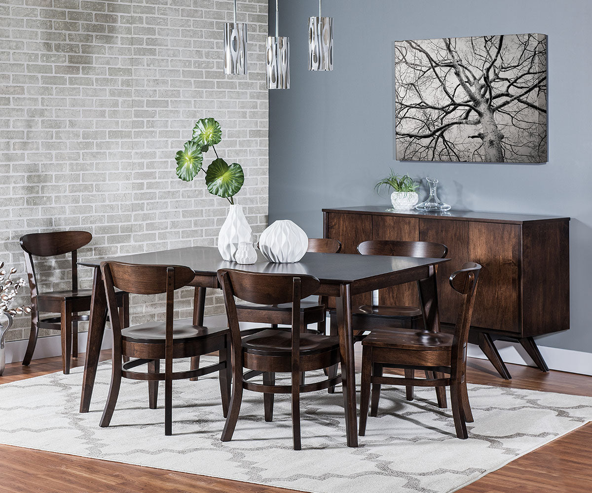 Dining room with wooden table and chairs, decorative plants, and a sideboard.