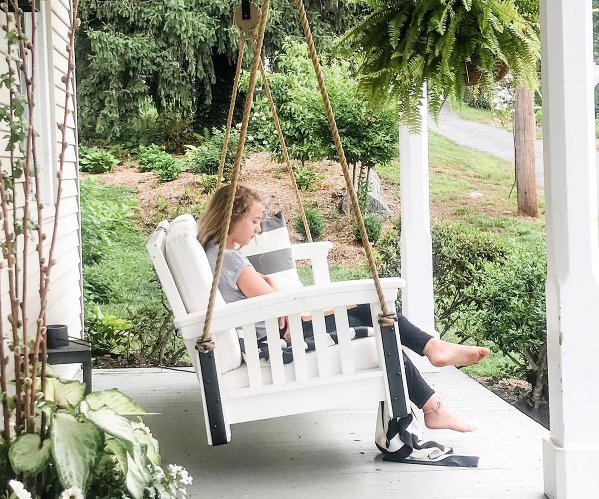 Southern Yankee Employee sitting on Poly Front Porch Swing reading a Book