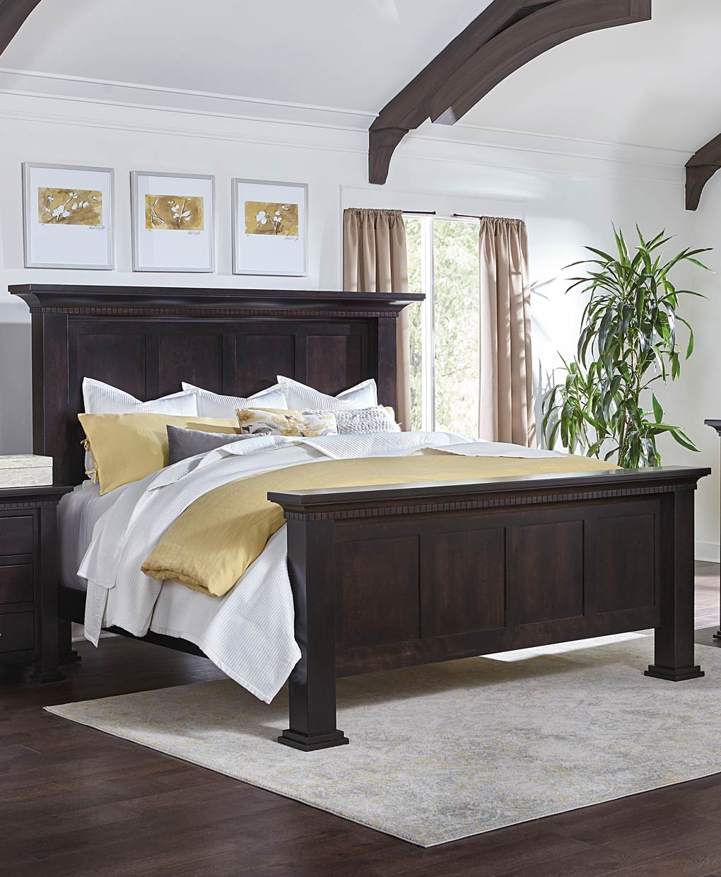 Bedroom with a dark wood bed frame, white bedding, and gold accents.