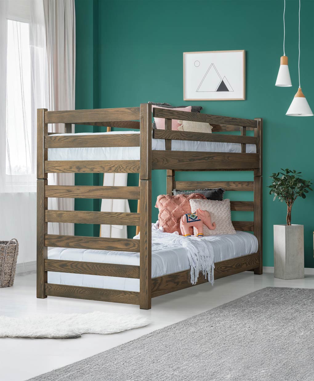 Wooden bunk bed with bedding in a room with teal walls and decor.