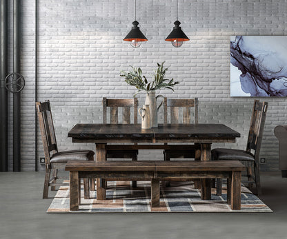 Dining room with wooden table, chairs, and bench against a brick wall.