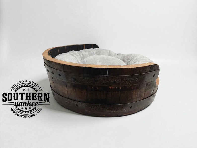 Wooden pet bed with gray cushion on a white background, featuring Southern Yankee Woodworking logo.