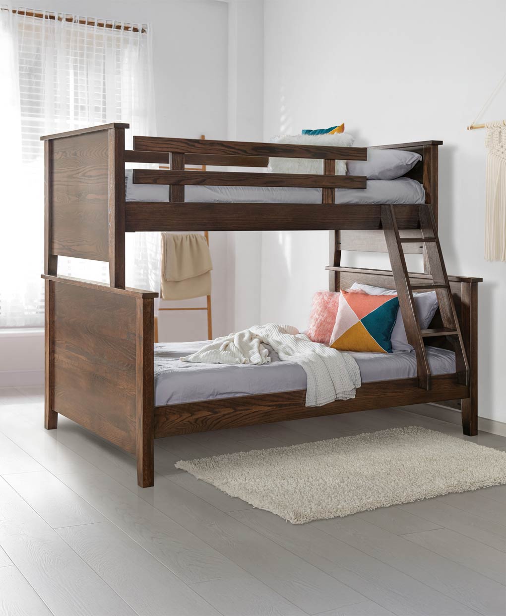 Wooden bunk bed in a room with white walls and a rug.