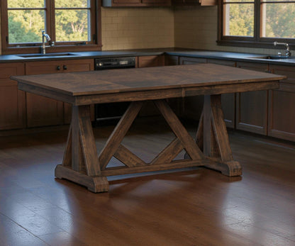 Wooden dining table in a kitchen setting with large windows.
