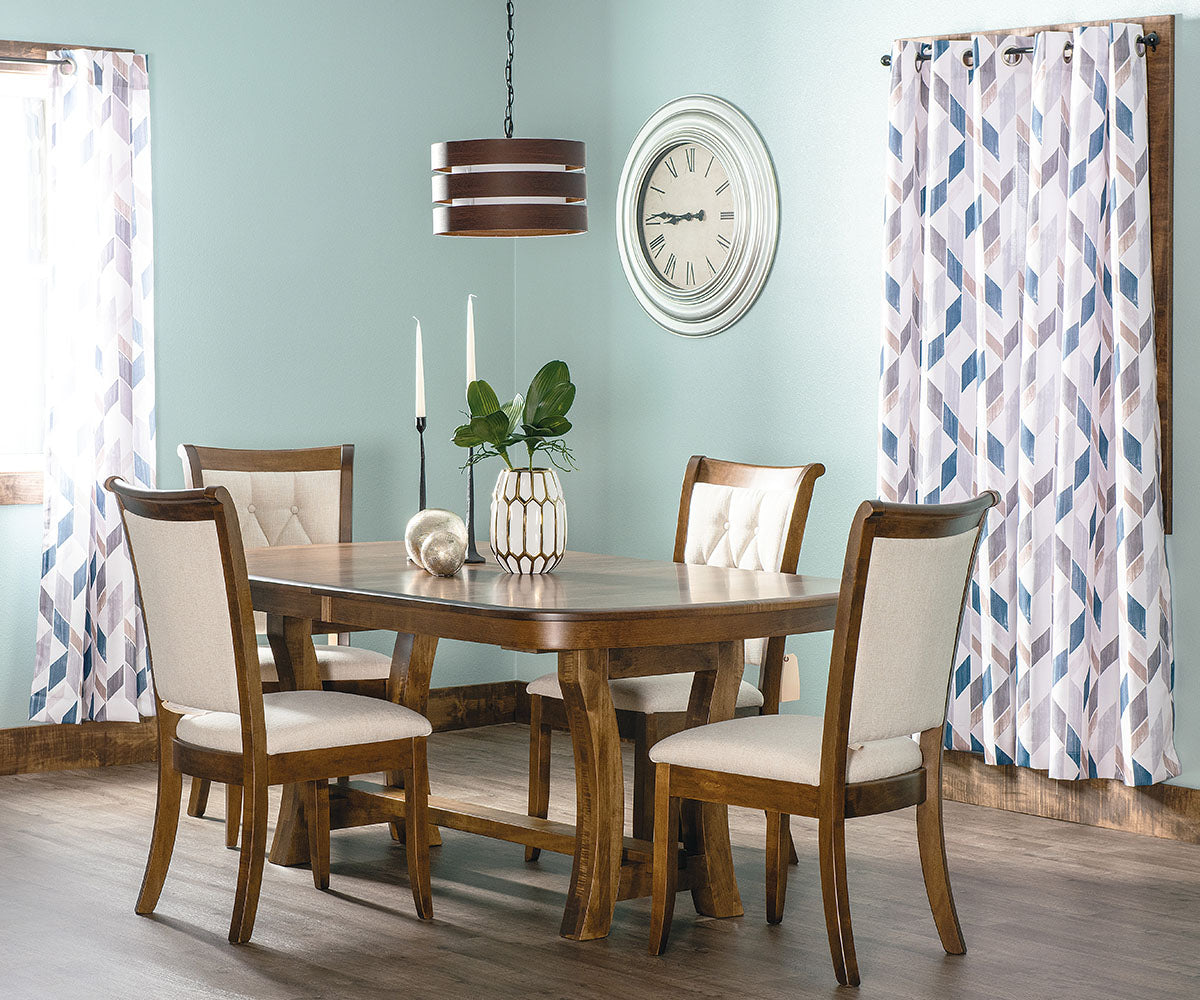 Dining room with wooden table and chairs, decorative plants, and patterned curtains.