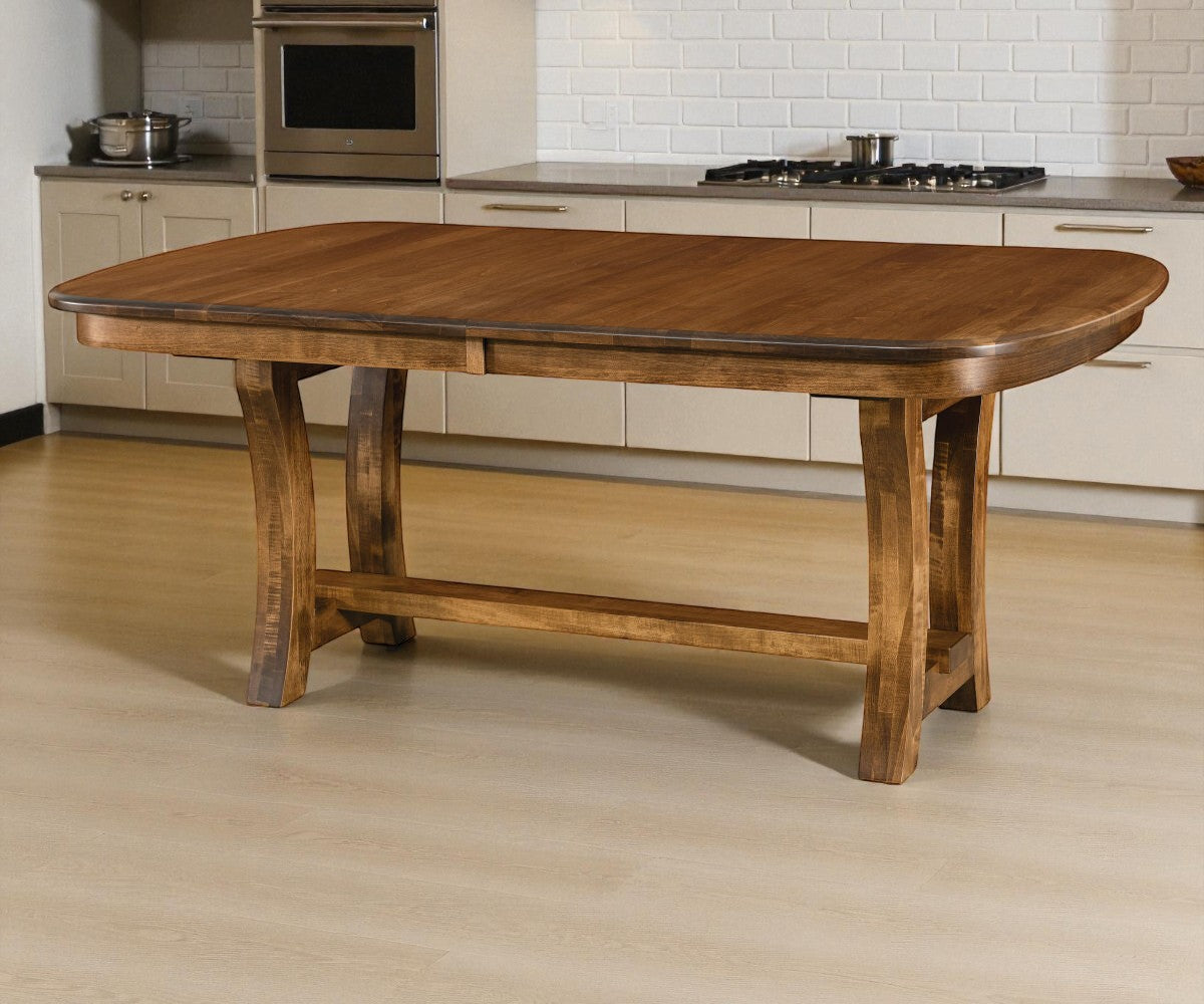 Wooden dining table in a kitchen setting with beige cabinets and appliances.