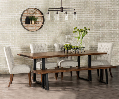 Dining room with wooden table, chairs, and bench against a brick wall.