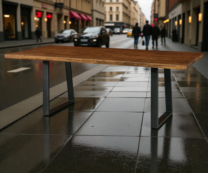 Wooden table on a wet city street with people and cars in the background