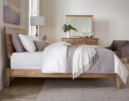 Neatly made bed in a bedroom with wooden furniture and decor.
