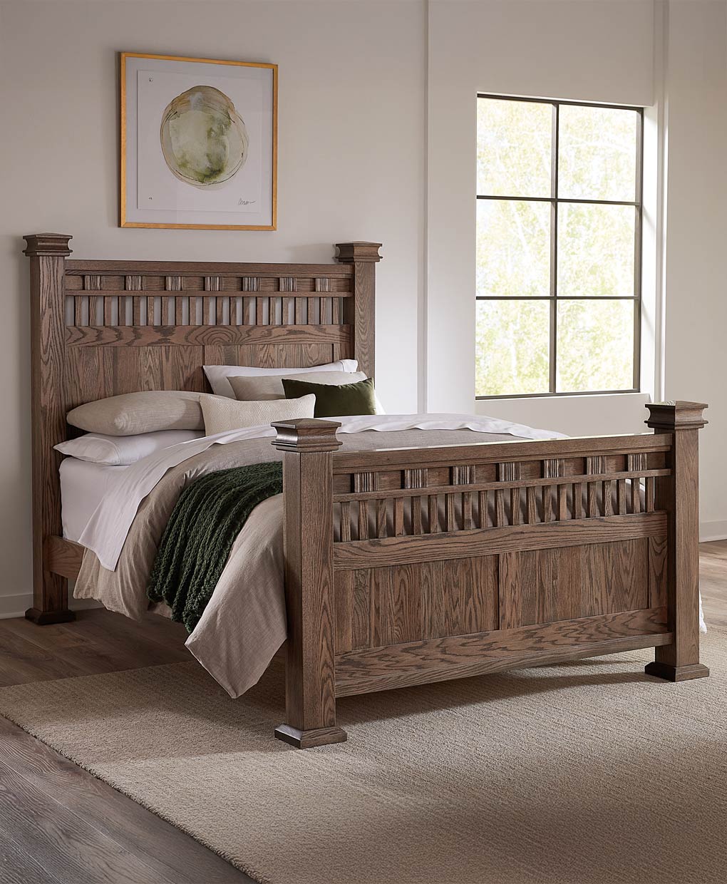 Wooden bed in a bedroom with a window and framed picture on the wall.