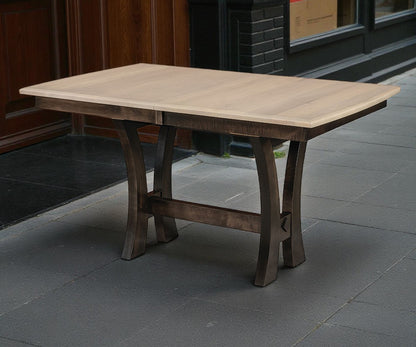 Wooden dining table on a stone pavement with a building in the background