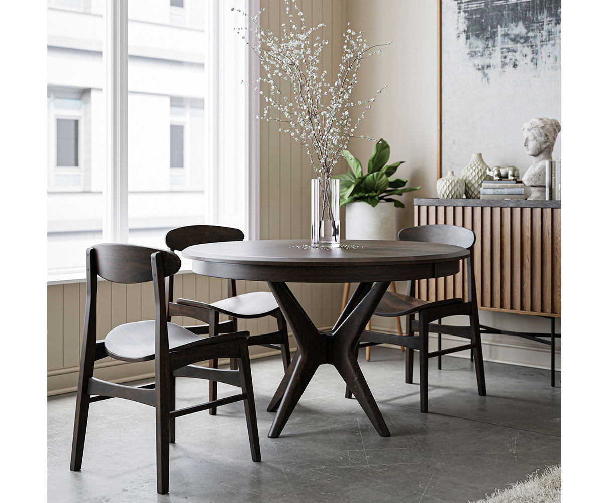 Dining room with a round dark wood table and chairs in a modern interior setting.