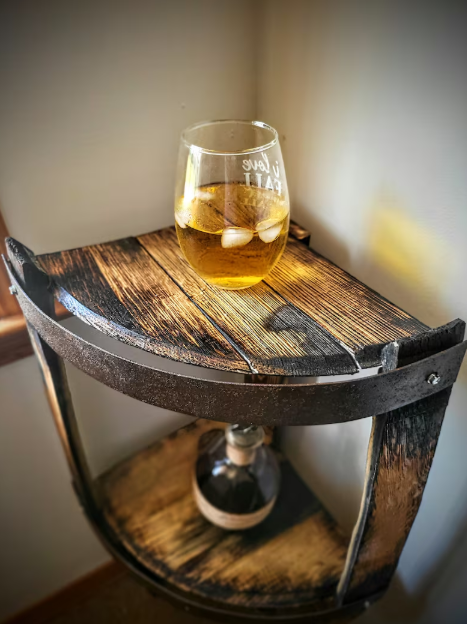 Wooden barrel side table with a glass of amber liquid on top