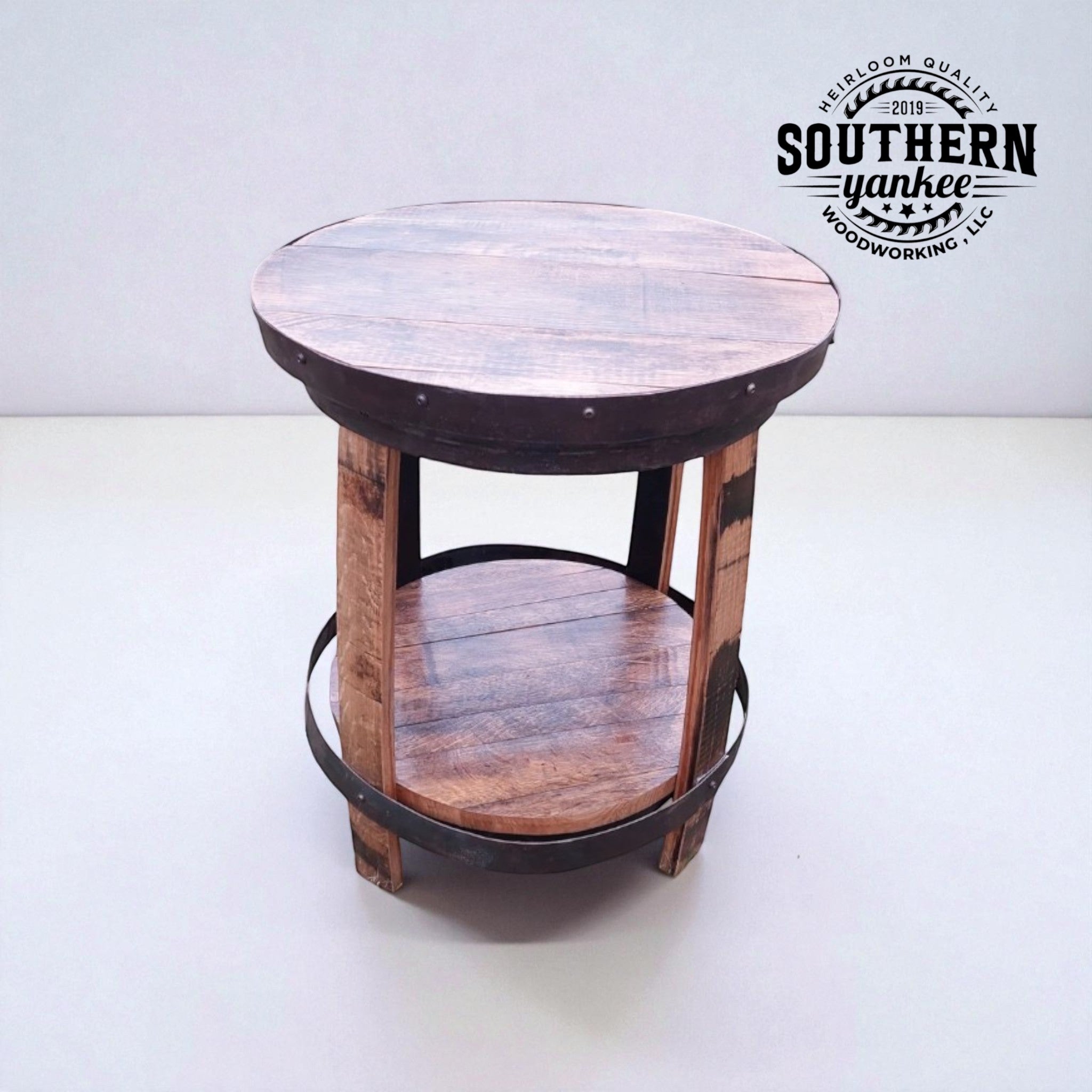 Round wooden side table with metal accents on a white background, featuring the Southern Yankee logo.